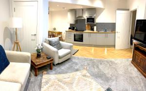 ドンカスターにあるHome Crowd Luxury Apartments - Park Viewのソファとキッチンのあるリビングルーム