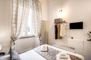 a white bedroom with a bed and a window at Trastevere Miracle Suite in Rome