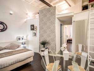1 dormitorio con 1 cama, mesa de cristal y sillas en Trastevere Miracle Suite, en Roma