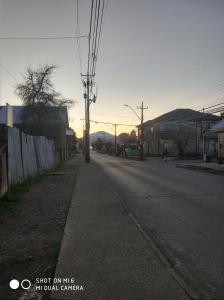an empty street in a town with the sun setting at Hospedaje Puerto Varas in Puerto Varas