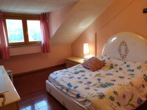 a bedroom with a bed with a floral bedspread at LOFT PRIMAVERA in Roccaraso