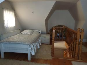 a small bedroom with a bed and a staircase at Home Belić Golija in Radaljica