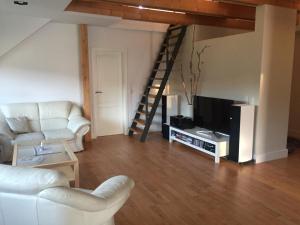 a living room with a couch and a tv and a staircase at Ferienwohnung Trede in Kurort Gohrisch