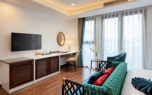 a living room with a couch and a desk at Minasi HanoiOi Hotel in Hanoi