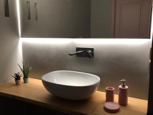 baño con lavabo blanco en una encimera de madera en Nenetta Rooms & Suites Monopoli, en Monopoli 111 fotos más