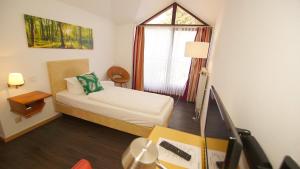 a small room with a bed and a window at gut-Hotel Tannenhof in Haiger