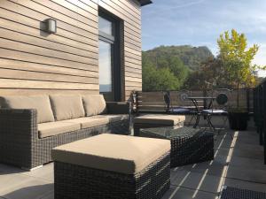 a patio with wicker furniture and a table on a house at A&N Prestige Apartments "Attika" close to BASEL and Rhine river in Grenzach-Wyhlen