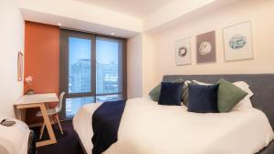 Un dormitorio con una cama y un escritorio y una ventana. en Miyana Suites, en Ciudad de México 57 fotos más