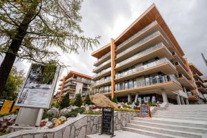 a large building with stairs in front of it at Apartmán LIANA Hrebienok C107 in Smokovce