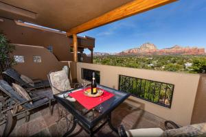 a balcony with a table with a bottle of wine at A Sunset Chateau in Sedona
