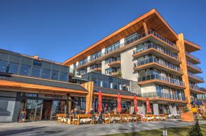 a building with tables and chairs in front of it at Matrix Apartments Hrebienok in Vysoke Tatry - Stary Smokovec