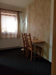 a dining room with a table and chairs and a window at Penzion V Maštali in Kněževes