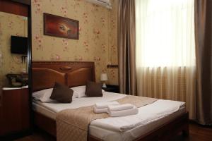 モスクワにあるLefortovsky Dvorik Hotelのベッドルーム1室(ベッド1台、タオル2枚付)