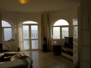 a bedroom with two arched windows and a television at Villa Sky Music in Obzor