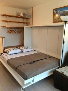 uma cama num quarto com uma estrutura de cama em Studio pied des pistes em Villard-de-Lans