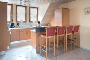 a kitchen with a bar with chairs and a counter at Fewo im Naturpark in Spiegelberg