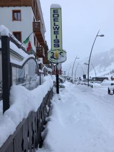 una calle cubierta de nieve junto a un edificio en Hotel Edelweiss 3 Stelle SUPERIOR en Breuil-Cervinia