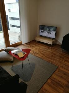 een woonkamer met een televisie en een rode tafel bij Ferienhaus Adela in Schruns