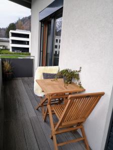 a wooden table and a chair on a balcony at Ferienhaus Adela in Schruns-Tschagguns