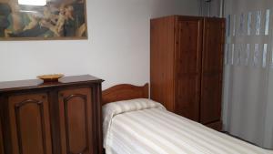 a bedroom with a bed and a dresser next to a cabinet at Appartamentino Le Stelle in Roccaraso