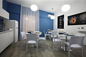 a dining room with white tables and white chairs at B&B High Definition in Pellaro