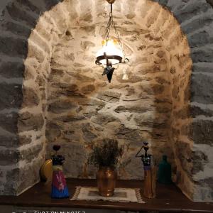 una lámpara de araña colgada de una pared de piedra en una habitación en Nimet Hanım Konağı, en Safranbolu