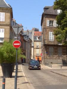 une voiture conduisant dans une rue avec un panneau rouge dans l'établissement Studio Moulins, à Moulins