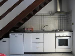 a kitchen with white cabinets and a stove at Maison Jasmine in Aosta