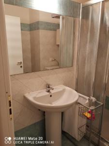 une salle de bain avec un lavabo et un miroir dans l'établissement Holiday place, à Fano