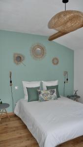 1 dormitorio con 1 cama blanca grande y paredes azules en L'Ostal de l'Antougnou, en Cavanac