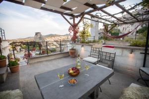 a patio with a table and glasses of wine at Asmalı Cave House in Uçhisar