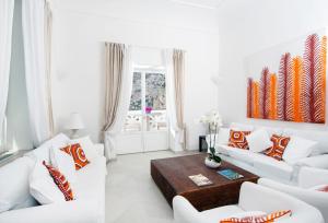 a white living room with white couches and a table at Villa Mariuccia Capri in Capri