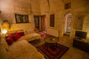 a living room with a couch and a table at Asmalı Cave House in Uchisar