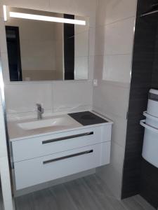 La salle de bains blanche est pourvue d'un lavabo et d'un miroir. dans l'établissement Appartement 4/6 pers plein sud. Front de neige, à Isola 2000