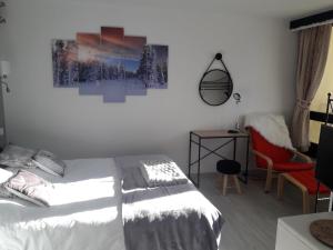 1 dormitorio con 1 cama, 1 silla y 1 pintura en Appartement 4/6 pers plein sud. Front de neige en Isola 2000