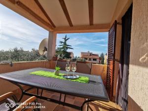a table on a balcony with two wine glasses at Apartment Brioni Sea,Garden,Poll view 2 plus 2 80m2 tiki bar in Peroj