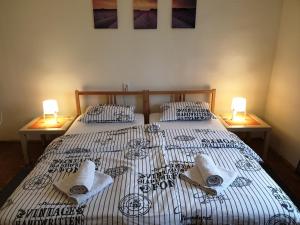 1 dormitorio con 2 camas, toallas y 2 lámparas en Sašo Rooms & Apartments, en Liubliana