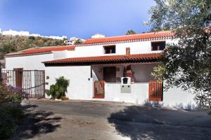 a white house with a red roof at Vivelorural casa Tunte 1, piscina y terraza in San Bartolomé de Tirajana