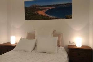 une chambre avec un lit avec deux lumières sur des tables de nuit dans l'établissement APARTAMENTO VISTA MAR LA TORTUGA, à Tarifa 27 autres photos