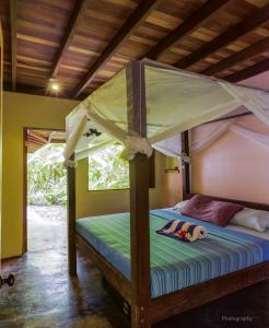 een slaapkamer met een hemelbed bij Casa Mil Flores in Cabo Matapalo