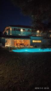 una casa con piscina por la noche en Hotel El Refugio nudista naturista opcional en Punta del Este