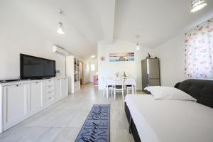 a bedroom with a bed and a tv and a table at Holiday Home Ana in Poljana