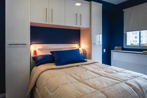 1 dormitorio con 1 cama con paredes azules y armarios blancos en Happy Mood Lapa - Confort & Style in Rio's Bohemia en Río de Janeiro