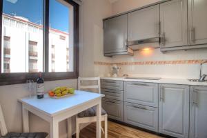 una cocina con armarios blancos y una mesa con fruta. en Sonia´s City View, en Santa Cruz de la Palma