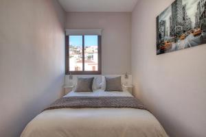 Dormitorio pequeño con cama y ventana en Sonia´s City View en Santa Cruz de la Palma