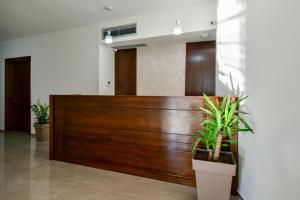 a wooden reception desk in a lobby with potted plants at Apartmani Djurovic in Ulcinj