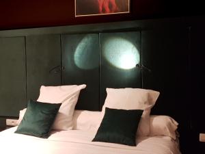 a bedroom with a bed with green and white pillows at Goodnight Antwerp in Antwerp