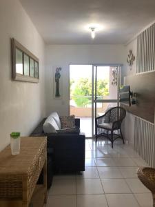 a living room with a couch and a table at Apto Praia Bertioga - 3 dormitorios sendo uma suite in Bertioga