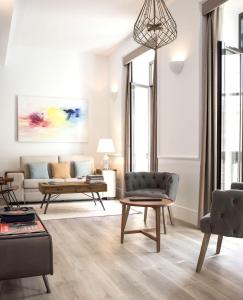 a living room with a couch and a table at Puerta Catedral Holiday Suites in Seville