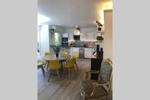 聖但尼的住宿－Fruitiers1，厨房以及带桌子和黄色椅子的用餐室。